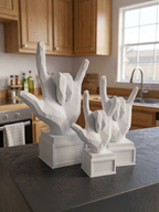 Statuina mano rock bianca in stampa 3D su una scrivania, soprammobile di design low-poly